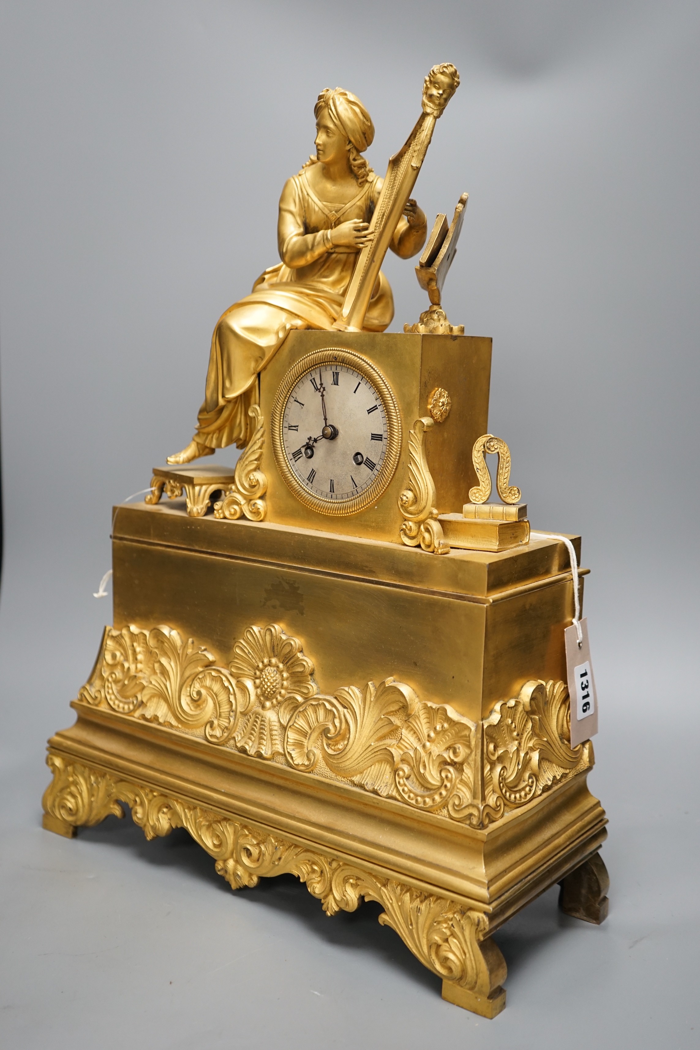 A 19th century French ormolu mounted clock with seated female Harpist decoration, with key, 49cm tall